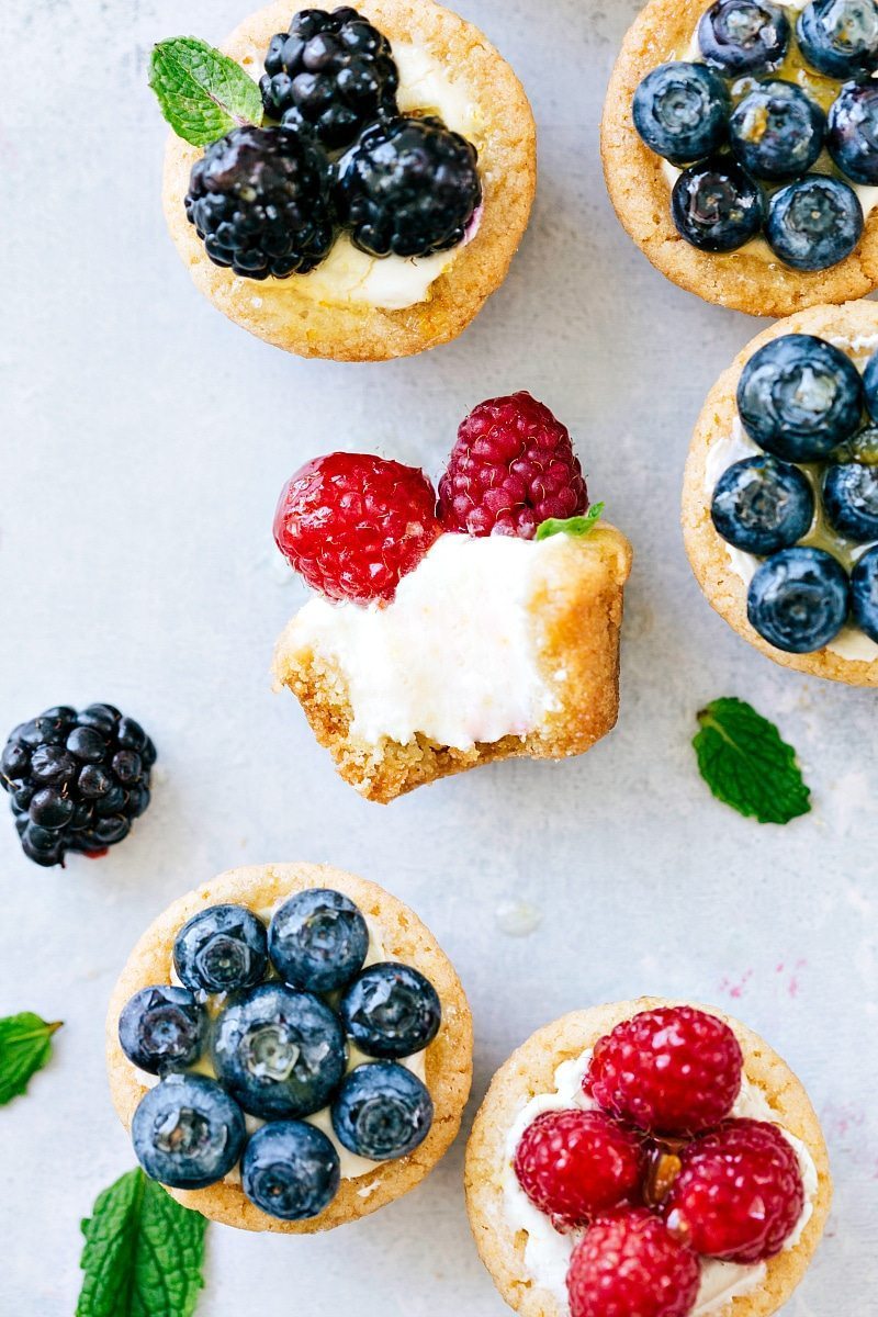 Overhead image of Mini Fruit Tarts with one of the tarts with a bite taken out of it.