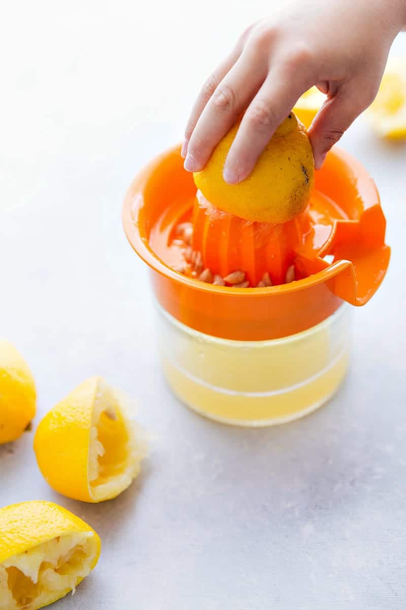 Up close shot of lemons being pressed through a juicer for lemon bars