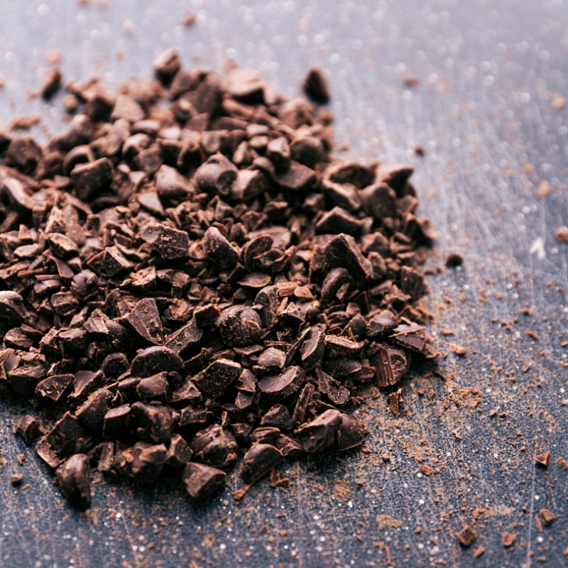 Finely chopped chocolate arranged on a cutting board, showcasing its rich texture.