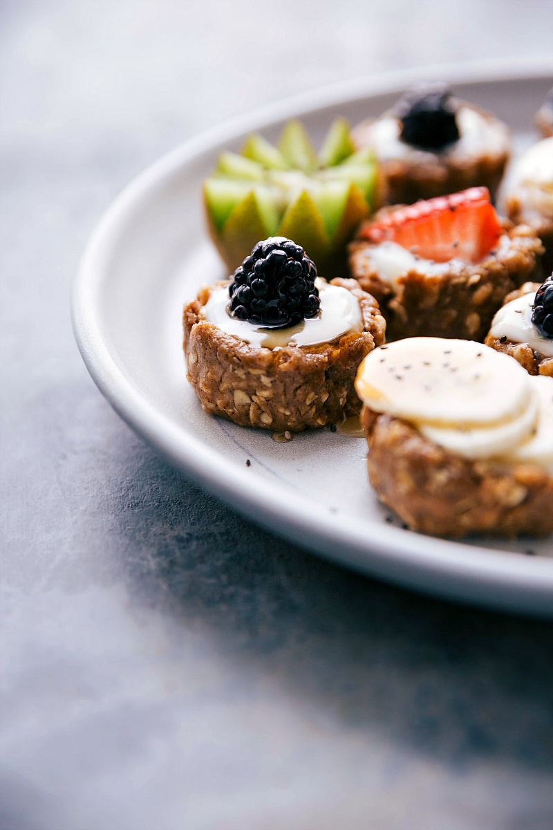 A plate full of healthy fruit tarts, showcasing both the crust and the delightful fruit toppings.