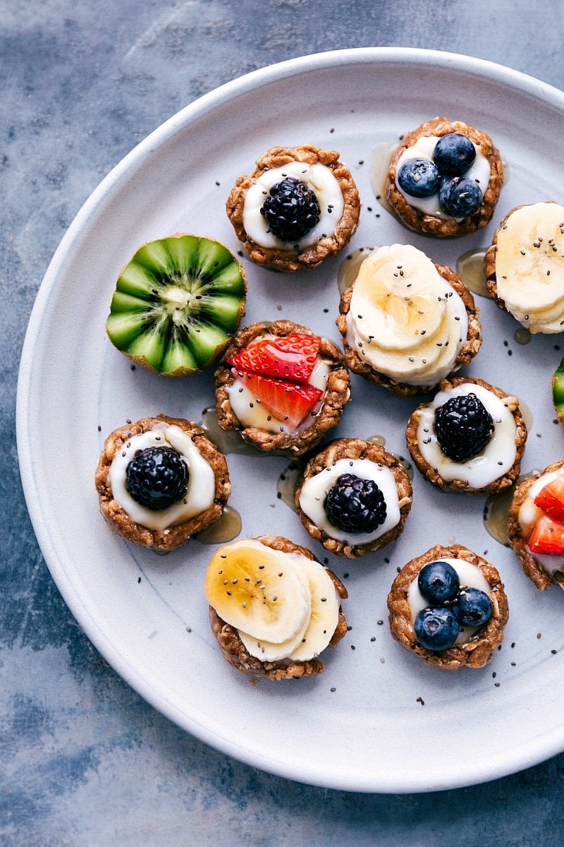 Healthy fruit tarts beautifully displayed on a tray, adorned with a variety of fresh fruit toppings.