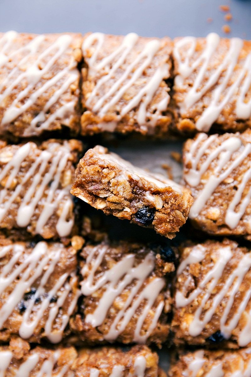 Image of the blueberry oatmeal squares cut in squares with one of them sitting up showing the inside