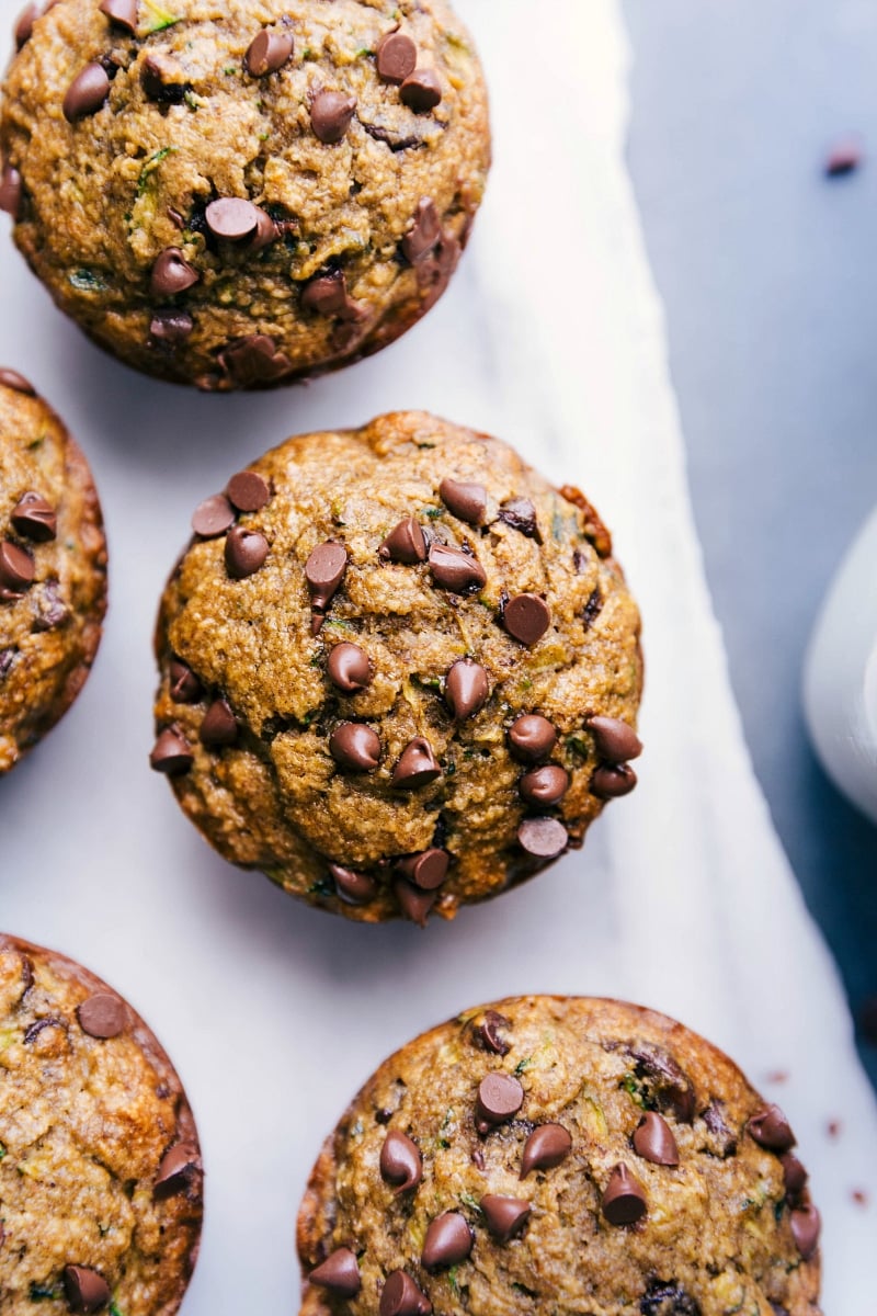 Gluten free zucchini muffins freshly out of the oven, topped with mini chocolate chips, ready to be enjoyed as a delicious breakfast or snack.