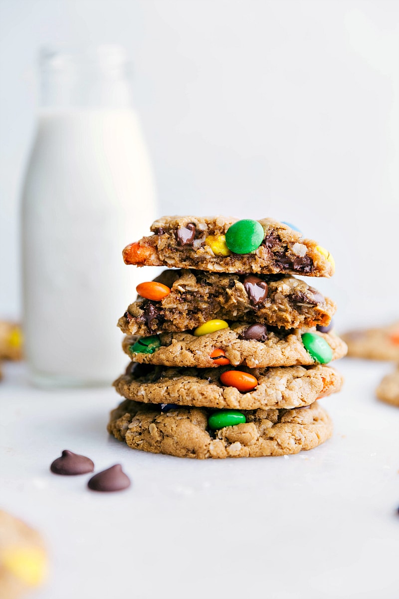 Image of Flourless Monster Cookies stacked on top of each other with one broken in half showing off the middle/