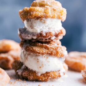 Two ice cream churro sandwiches stacked with ice cream oozing out the sides.