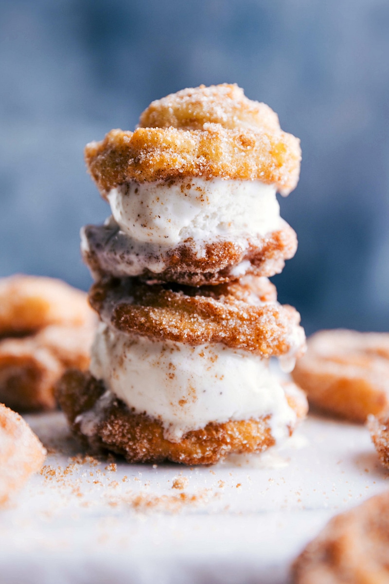 Two ice cream churro sandwiches stacked with ice cream oozing out the sides.