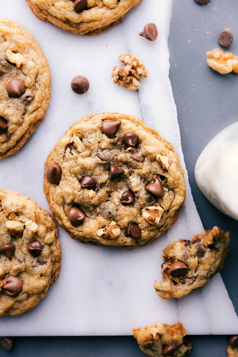 Overhead view of Doubletree Cookies, with a few chocolate chips and walnuts scattered nearby.