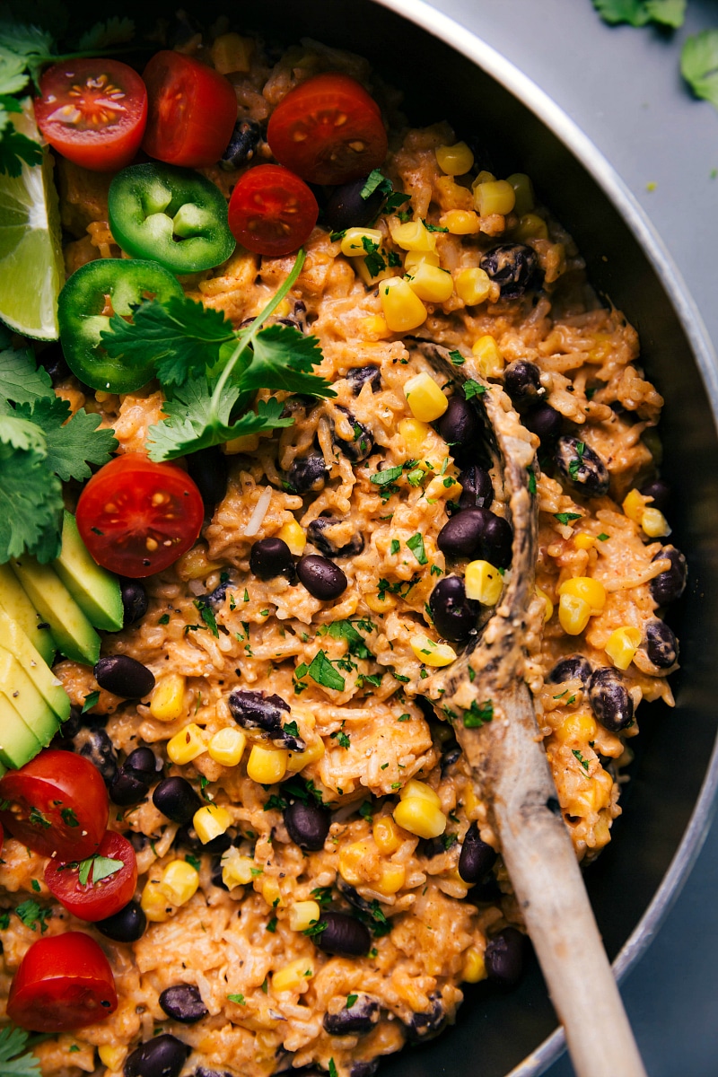 The finished Mexican Chicken and Rice, ready to be served, topped with fresh vegetables, creating a hearty and healthy meal.