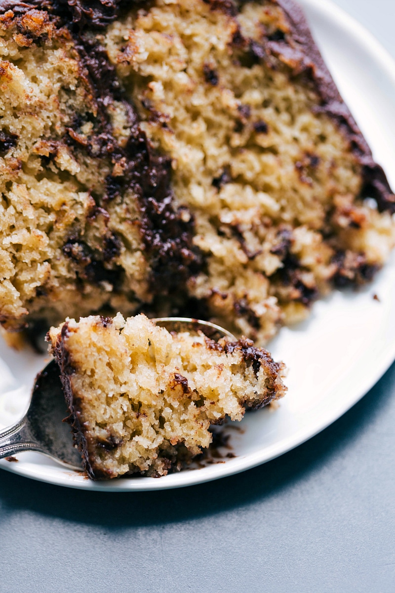 A slice of chocolate chip banana cake with a bite missing, revealing its fluffy interior