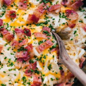 A warm, hearty scoop of crockpot hashbrown casserole, steaming and ready to be served.