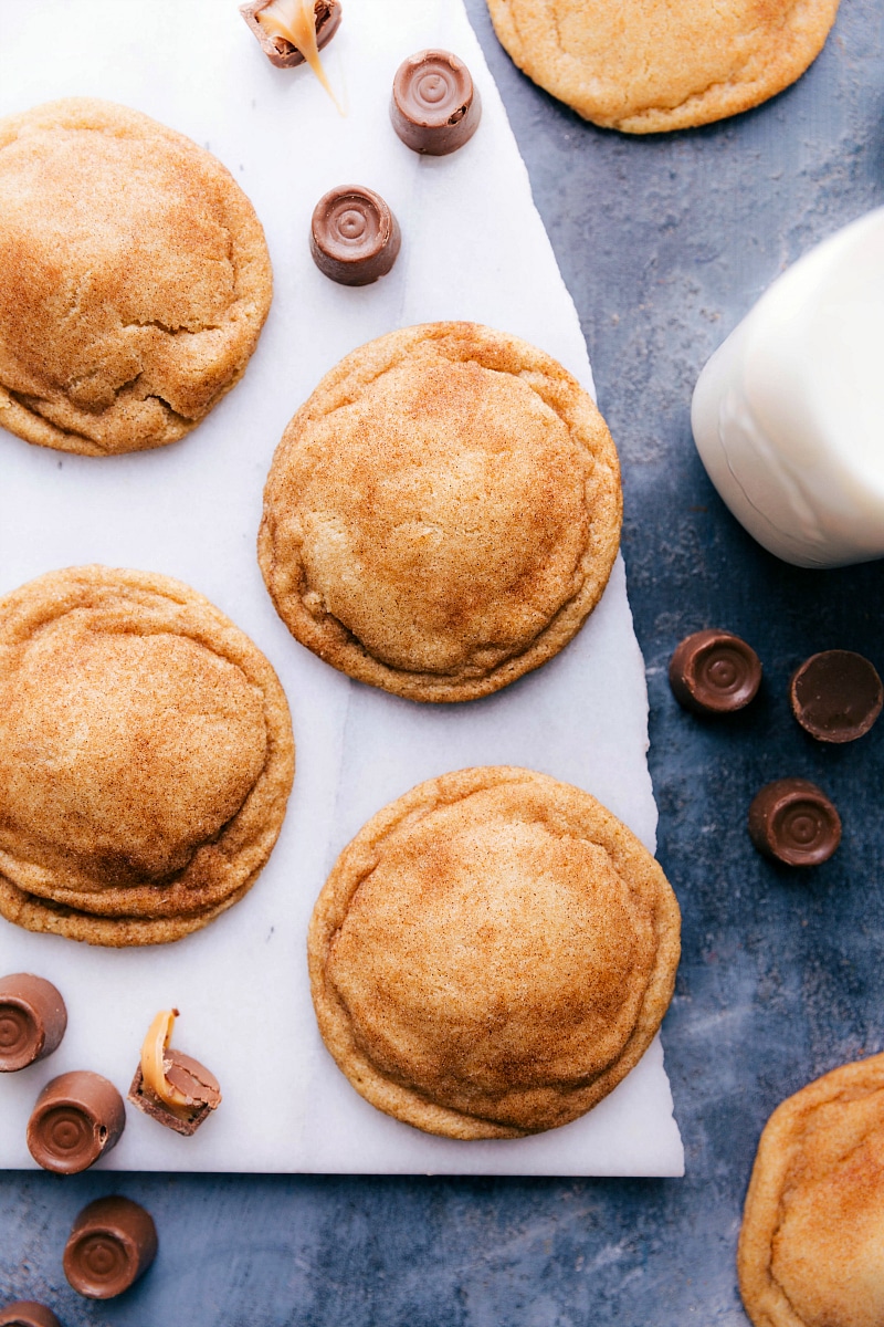 Overhead image of Caramel Snickerdoodle cookies with Rolos around them and milk.