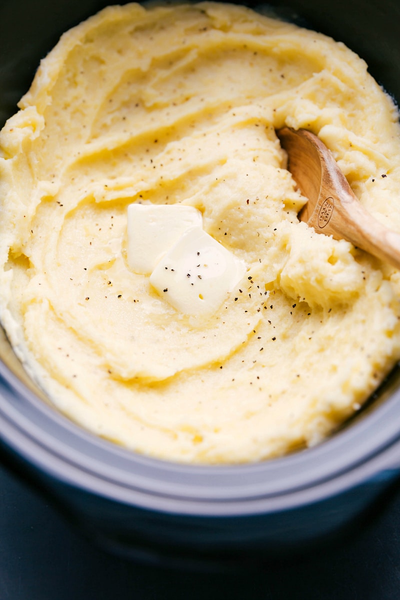 The finished crockpot mashed potato recipe topped with a dollop of butter, ready to be enjoyed.