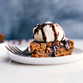 Gluten-free pumpkin cake on a plate, crowned with a scoop of ice cream, prepared for a delicious treat.