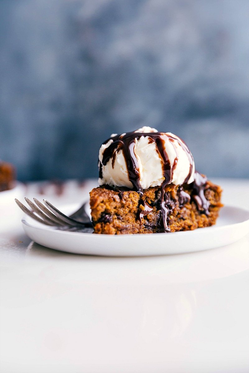 Gluten-free pumpkin cake on a plate, crowned with a scoop of ice cream, prepared for a delicious treat.