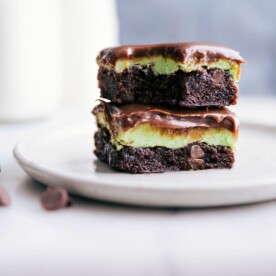Stacked squares of mint brownies with a bite taken out of the top one.