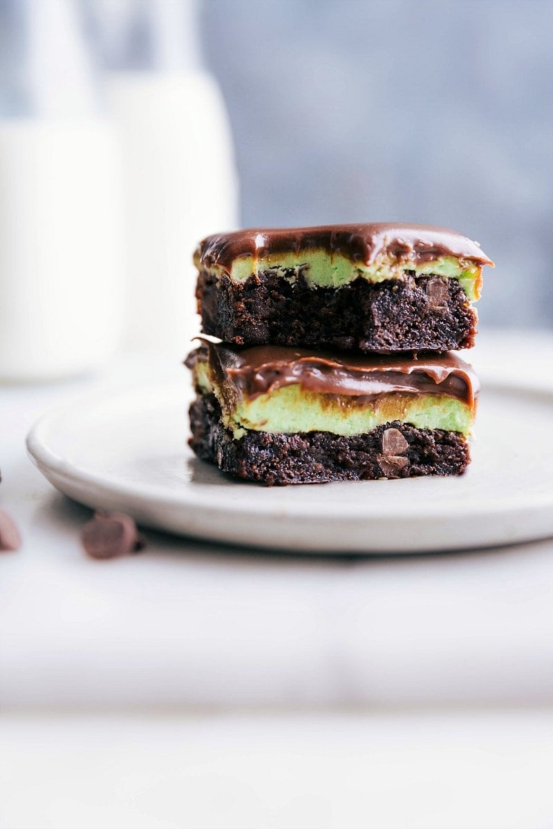 Up-close image of two squares of Mint Brownies stacked on top of each other with a bite taken out of the top one.