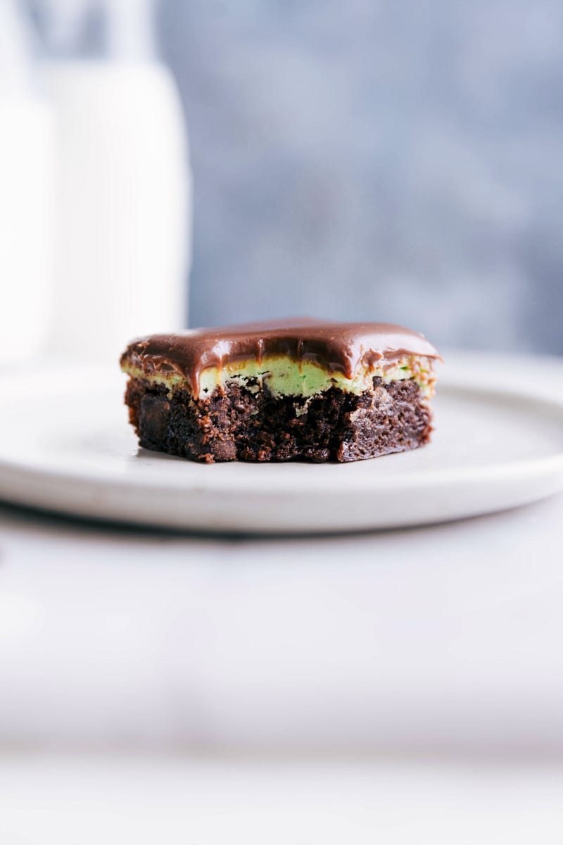 Chocolate mint brownies on a plate with a bite taken out of it, revealing its delicious interior.