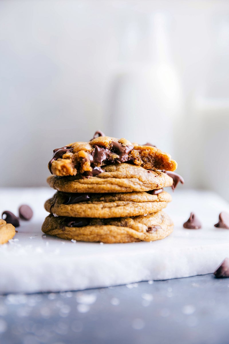 Stacked pumpkin chocolate chip cookies with a bite taken out of the top one.