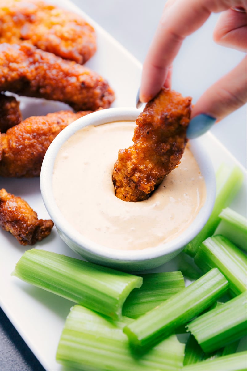 Image of a piece of chicken being dipped into the Chipotle Ranch Dip