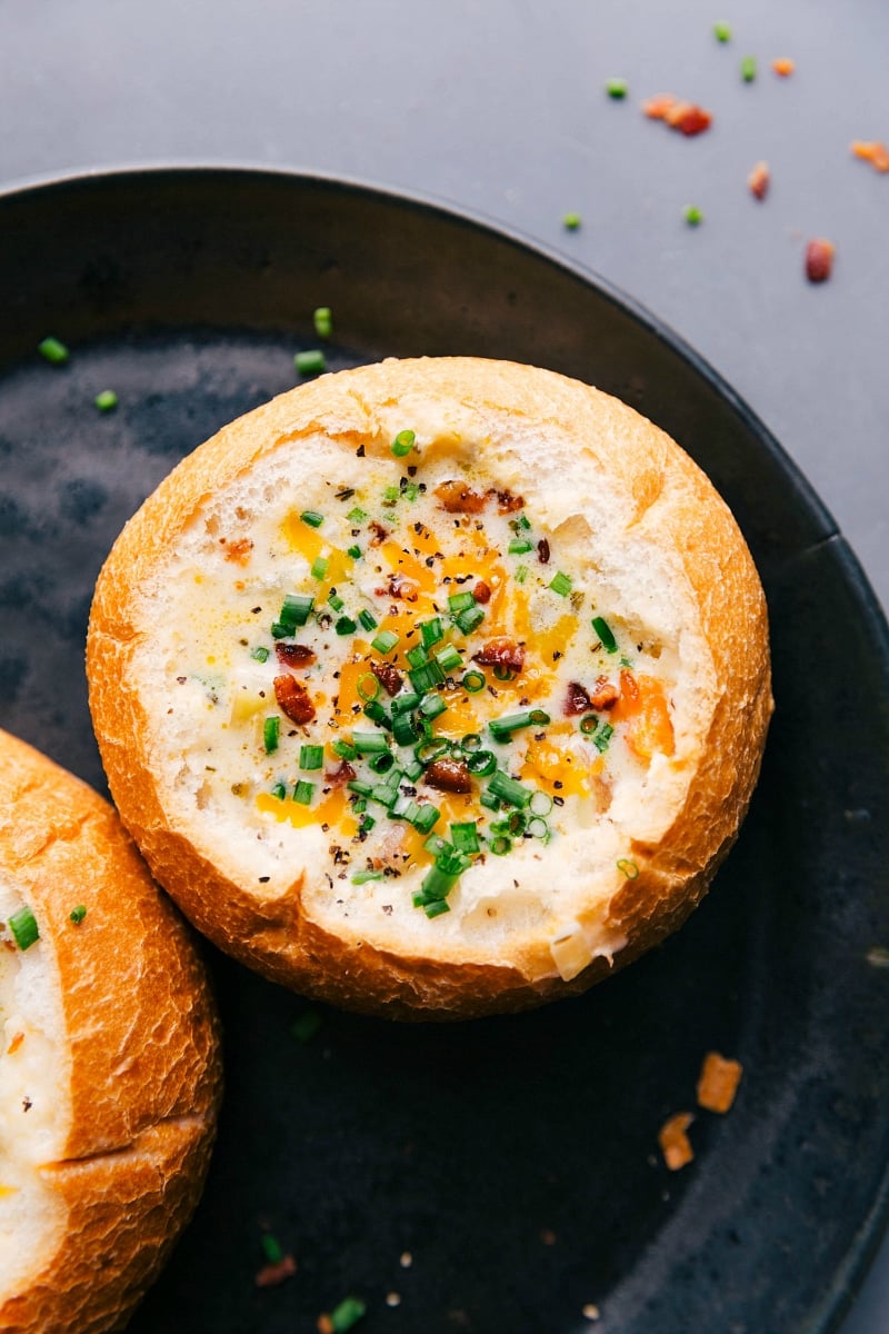 Hearty and warm potato soup served in a gorgeous bread bowl, topped with fresh herbs and cheese.