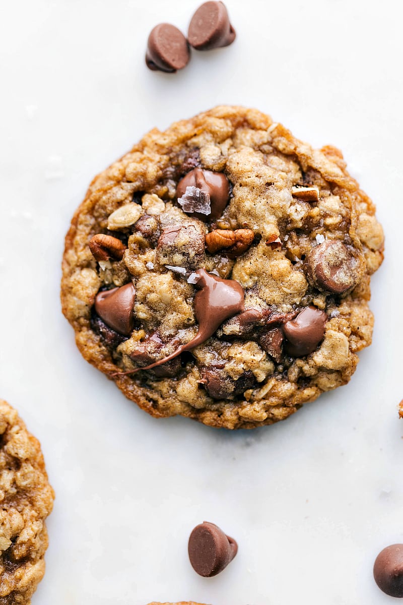 Freshly baked and delicious oatmeal pecan cookie with melted chocolate chips on top, a sprinkle of fresh sea salt, and baked pecans.