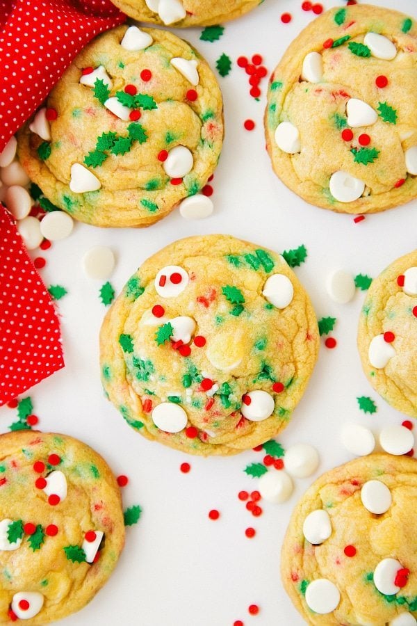 A batch of cake batter cookies in a festive holiday variation, adorned with red and green sprinkles and white chocolate chips, ready to spread holiday cheer through delightful treats.