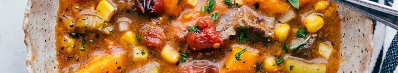 A bowl filled with hearty and delicious sweet potato stew, brimming with flavor and vegetables, accompanied by a spoon, inviting you to savor its wholesome goodness.