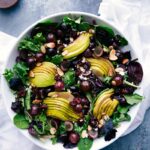 Vibrant pear, grape, and cherry green salad with cherry balsamic dressing on the side, a refreshing delight.