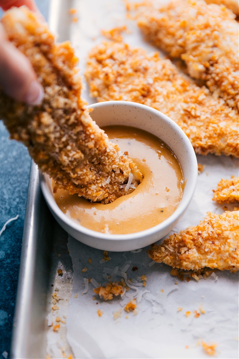 Dipping Coconut Chicken in the honey-mustard sauce
