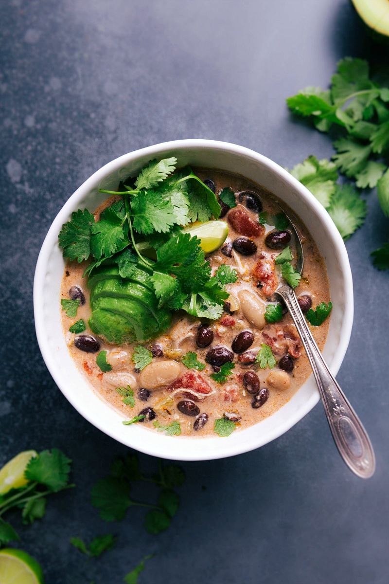 Warm bowl of green chile chicken enchilada soup topped with fresh herbs and avocado slices, ready to enjoy.