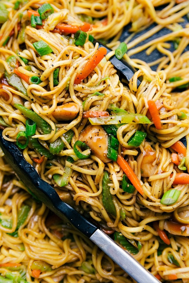 Prepared Chicken chow Mein with tongs in the skillet.