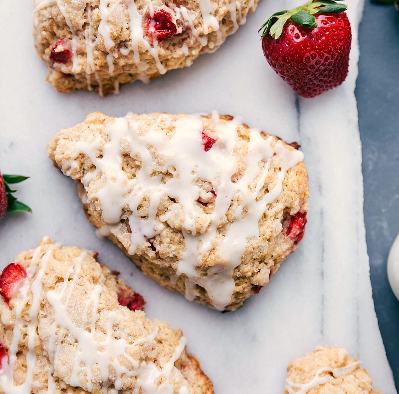 The finished strawberry scones generously drizzled with glaze, a delicious and delightful dessert.