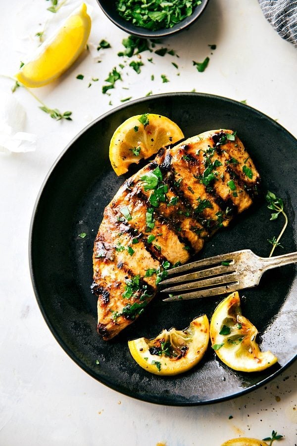 Grilled chicken on a plate, ready to eat.