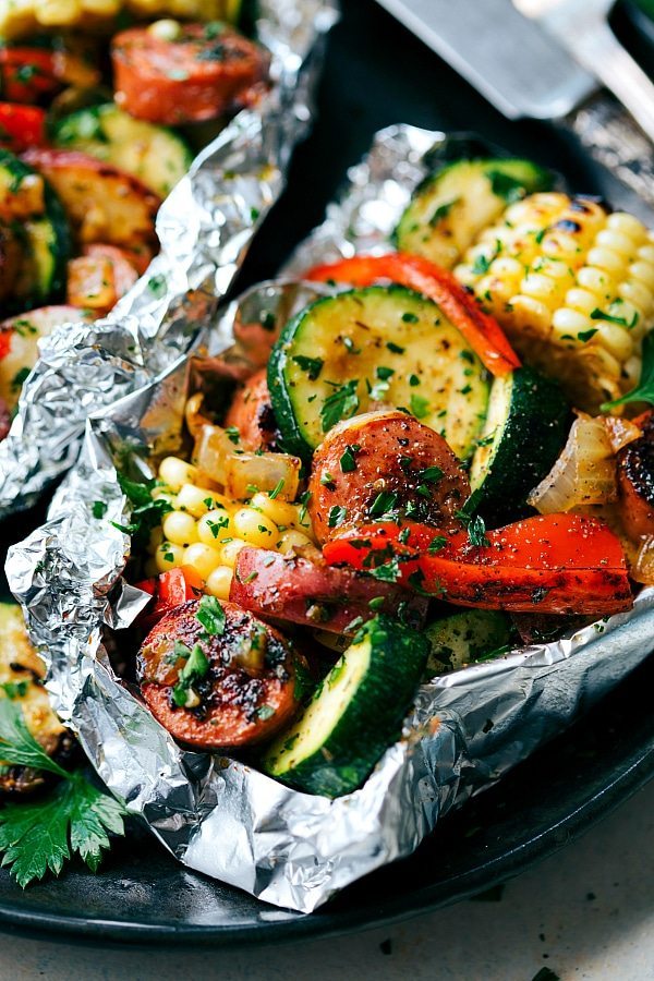 TIN FOIL SAUSAGE DINNER! These delicious and easy tin foil packets are so quick to assemble! They are packed with sausage, tons of veggies, and the best seasoning mix. Recipe from- chelseasmessyapron.com