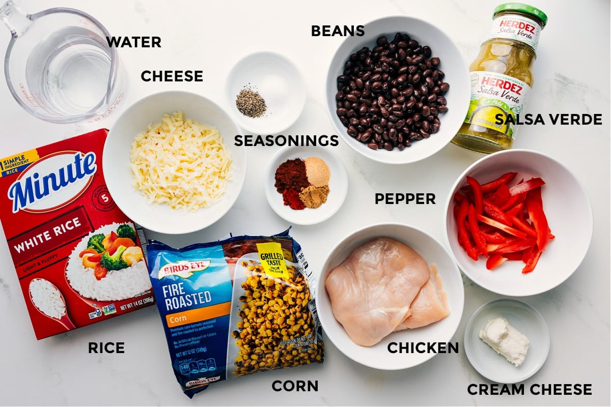 All the ingredients prepped and ready for easy assembly, including water, rice, cheese, corn, spices, beans, chicken, salsa verde, cream cheese, and peppers.