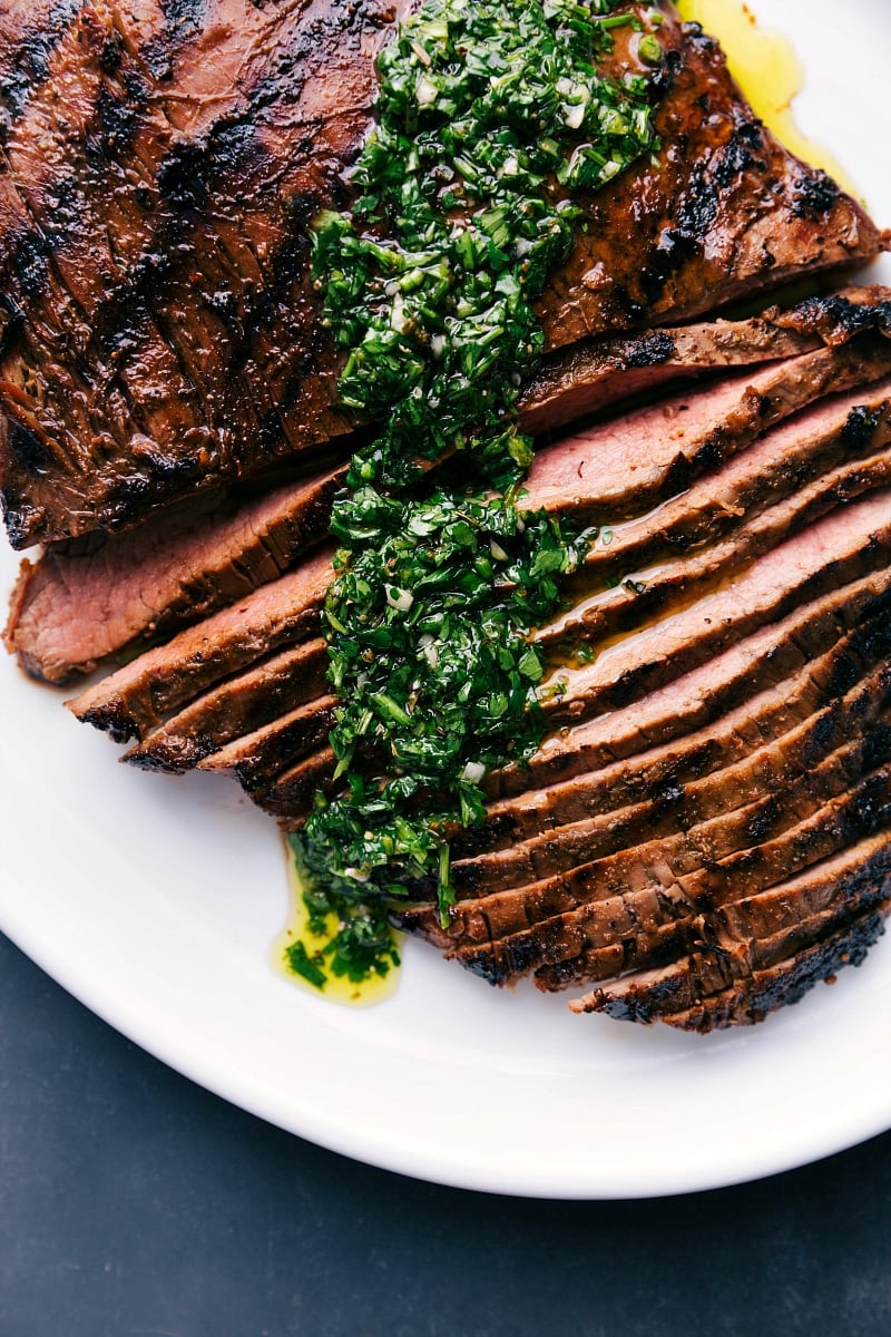 Sliced grilled flank steak topped with flavorful chimichurri sauce.