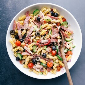 Large bowl of Italian pasta salad, brimming with delicious and complementary ingredients.