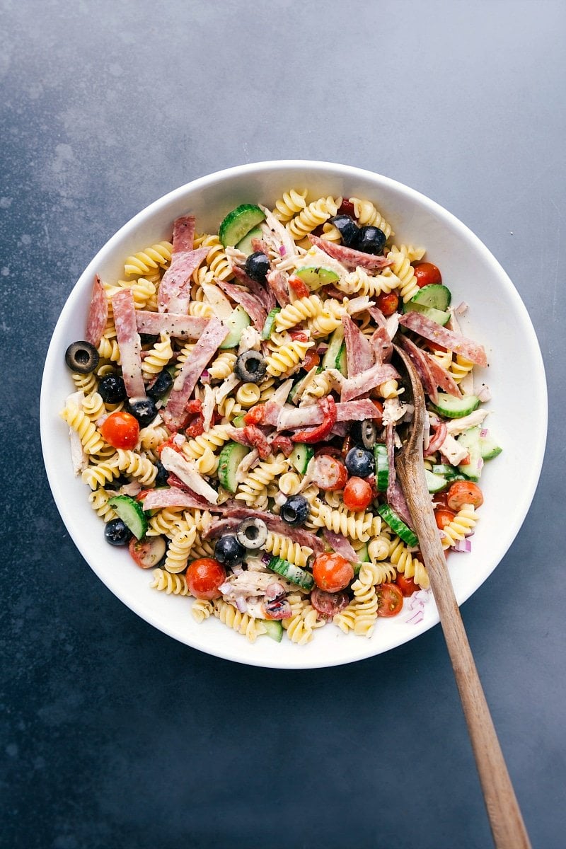 Large bowl of Italian pasta salad, brimming with delicious and complementary ingredients.