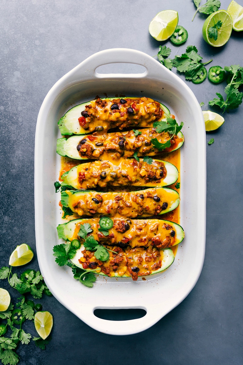 View of a Pan Full of Mexican Zucchini Boats Topped with Melted Cheese and Fresh Herbs View of a pan full of Mexican zucchini boats topped with melted cheese and fresh herbs.