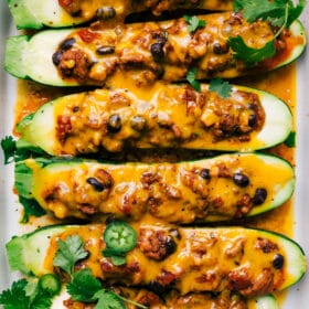 Finished mexican zucchini boats with melted cheese and fresh herbs on top, a hearty and healthy meal.
