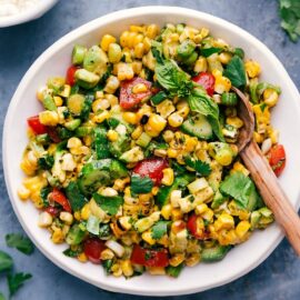 Fresh corn salad in a bowl with a serving spoon.