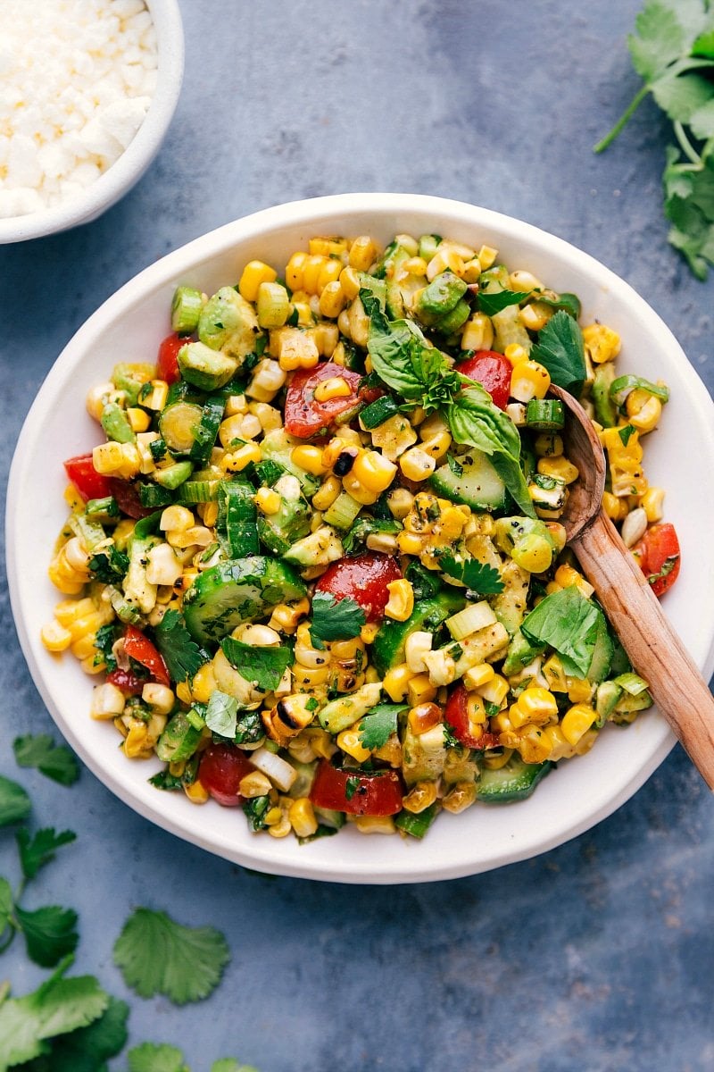 Fresh corn salad in a bowl with a serving spoon.