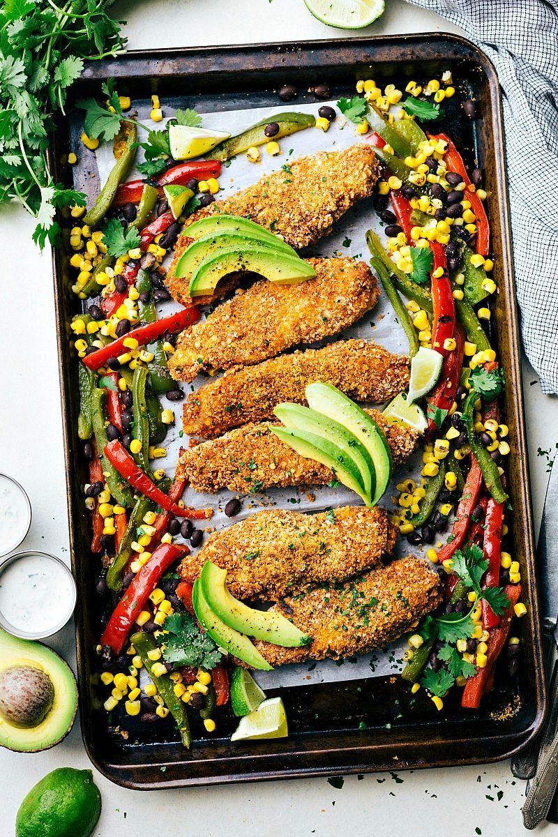ONE PAN Mexican Tortilla Chicken and Veggies! Tortilla crusted chicken baked on one pan with peppers, corn, and black beans! A delicious, hearty, and healthy meal the whole family will love! Recipe via chelseasmessyapron.com