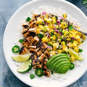 Ready-to-eat Pineapple Chicken over rice, with avocado and lime on the side.