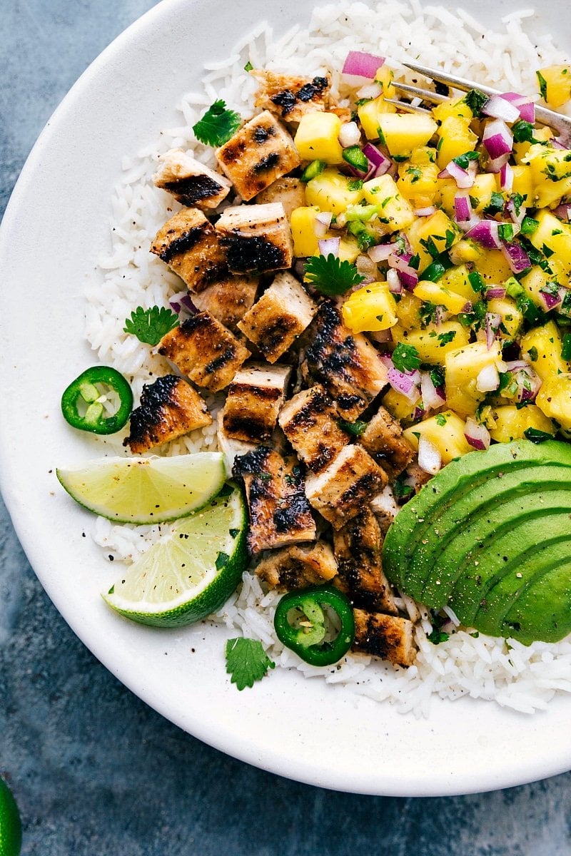 Overhead shot of grilled chicken, mango, avocado and rice.