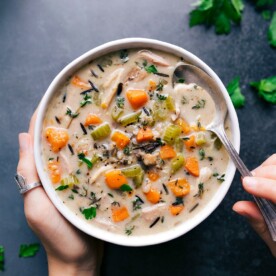 A bowl filled with crockpot chicken-wild rice soup, ready to be eaten, showcasing a delicious and comforting meal.