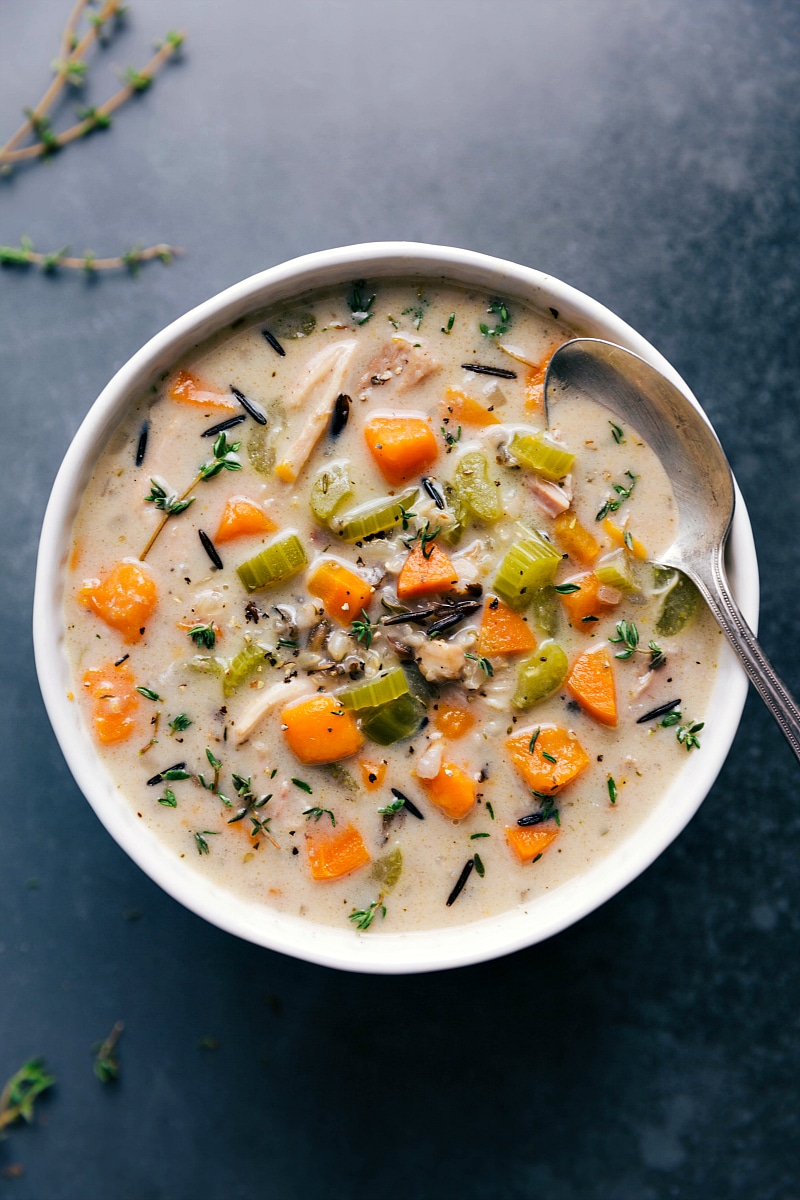 A bowl filled with the finished crockpot chicken and wild rice soup, topped with fresh herbs, showcasing a flavorful and hearty meal ready to be enjoyed.