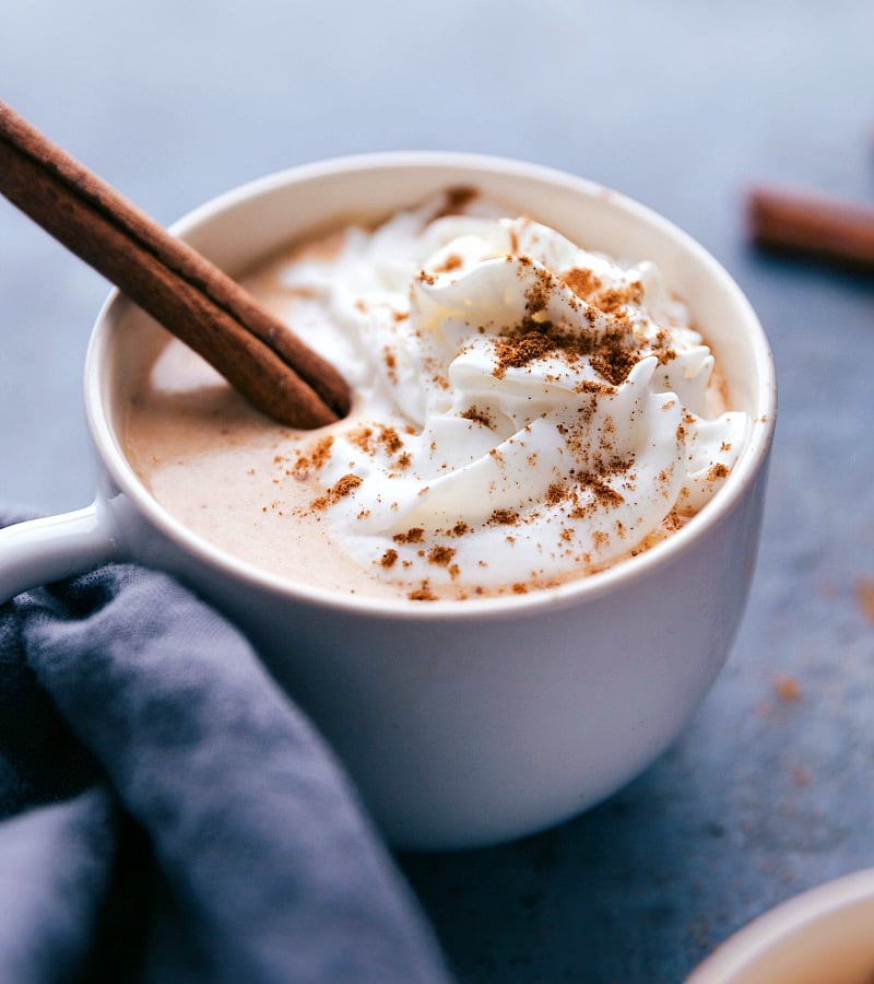 Pumpkin spice latte steamer adorned with whipped cream and a cinnamon stick, a delightful autumn treat.