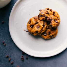 Soft pumpkin cookies on a plate with warm, melting chocolate chips, delicious and ready to be eaten.