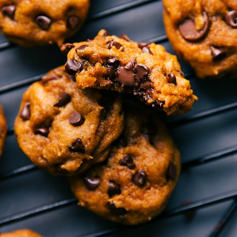 Overhead image of Soft Pumpkin Cookies on a cooling rack, with a bite taken out of one of them.